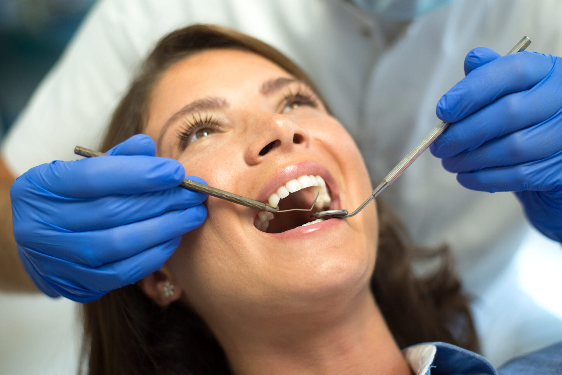 Dentist repairing and checking teeth of a young woman  at the dental clinic